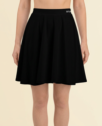 OUTLENA Elevate Skater Skirt Black on model, logo detail